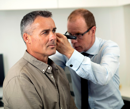 Doctor examinando los oídos de un paciente.