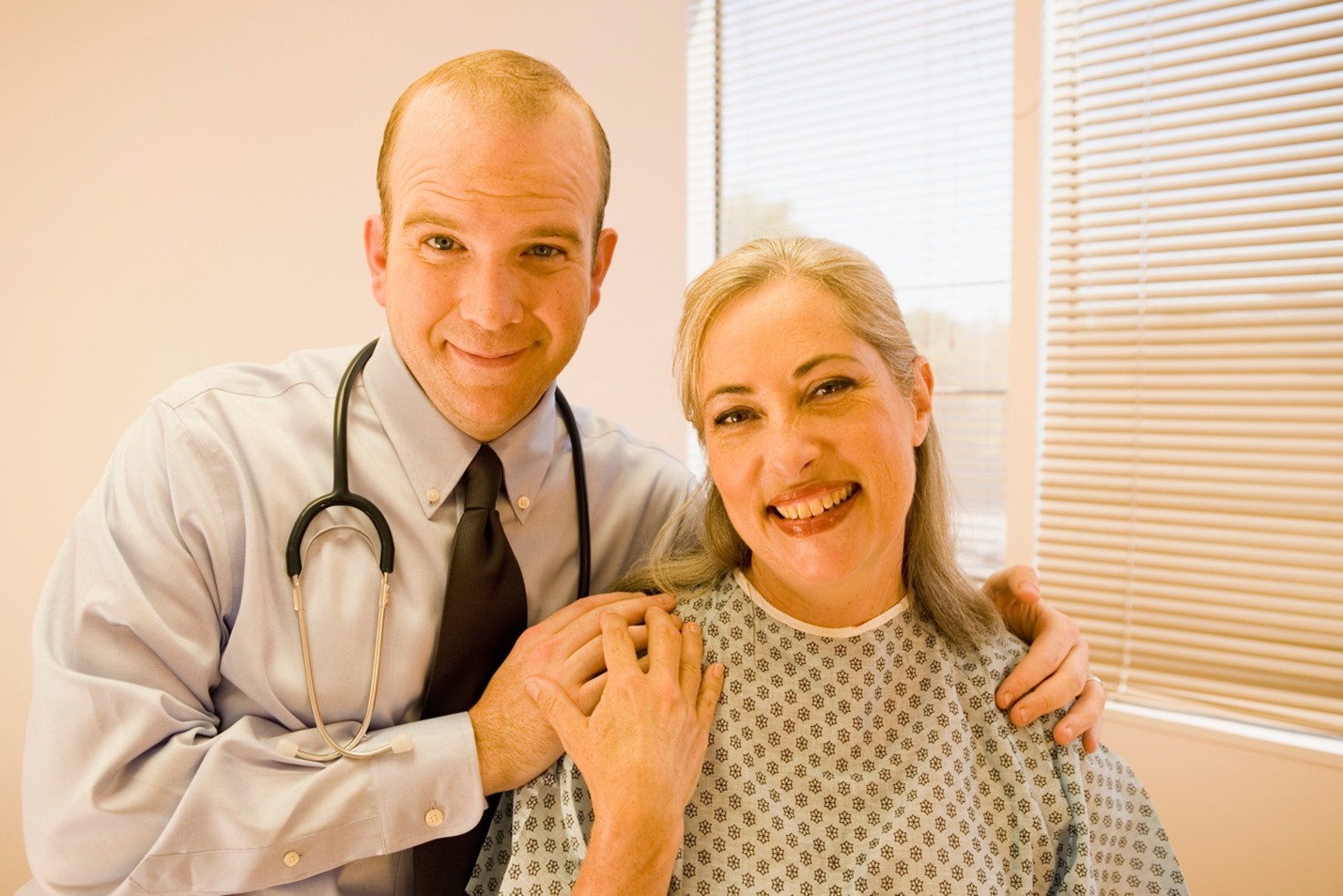 paciente mujer y doctor sonriendo abrazados.
