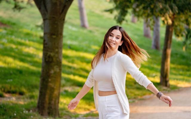 Mujer sonriendo mientras camina en un parque.