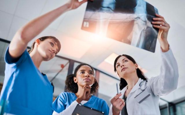 Doctora y enfermeras evaluando una radiografía.