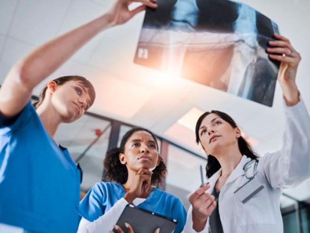 Doctora y enfermeras evaluando una radiografía.